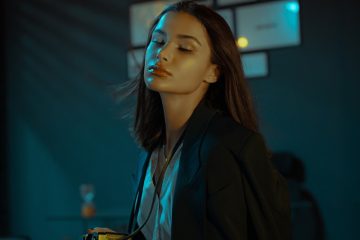 woman in black blazer standing near black flat screen tv