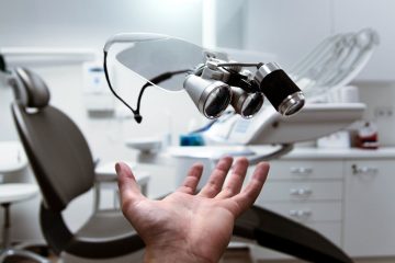 Floating dental loupes in a modern, clean dentist office setting.